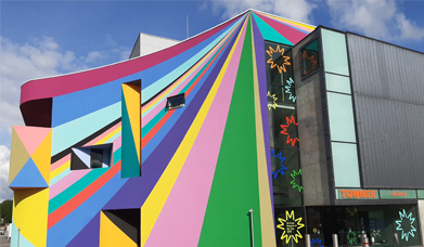 Exterior of Towner art gallery with vibrant multicoloured diagonal stripes painted on the outside walls